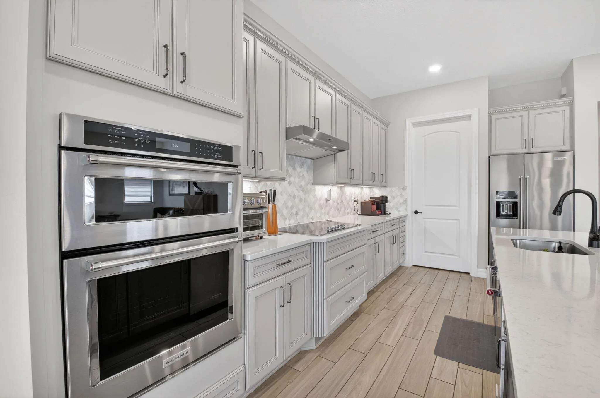Oversized kitchen with walk-in pantry, 42" cabinets, KitchenAid appliances, quartz countertops, and much more!