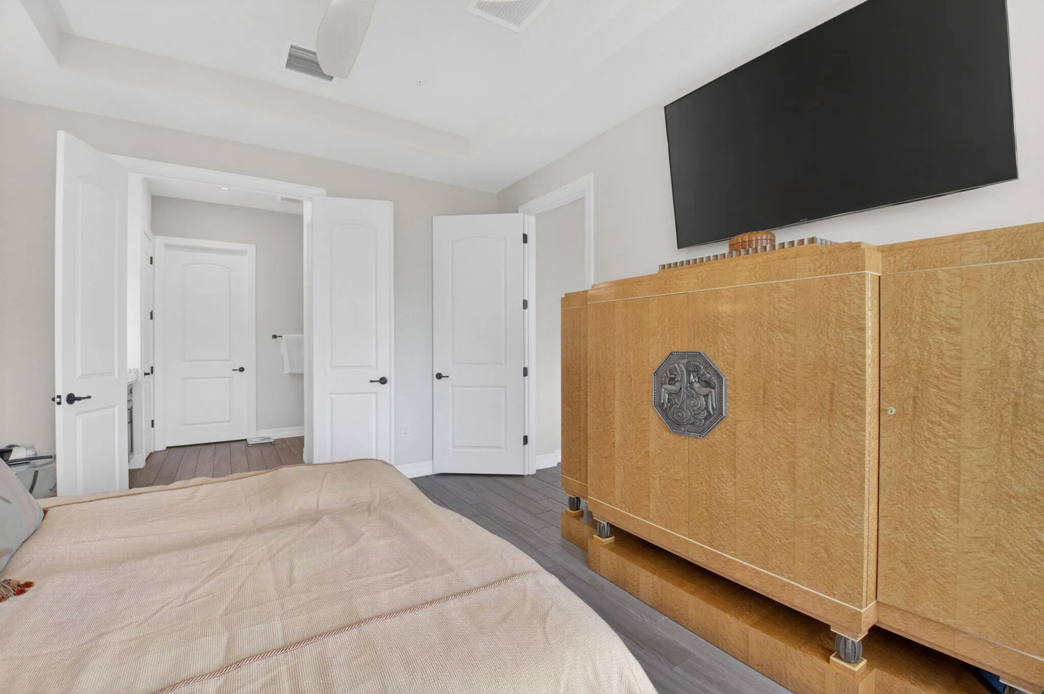 Primary bedroom with trey ceiling, lake views, en suite, and custom walk-in closet.