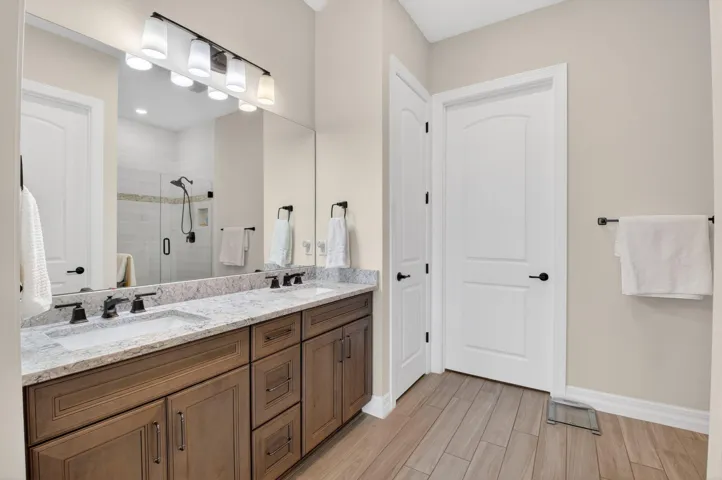 Primary bedroom with trey ceiling, lake views, en suite, and custom walk-in closet.