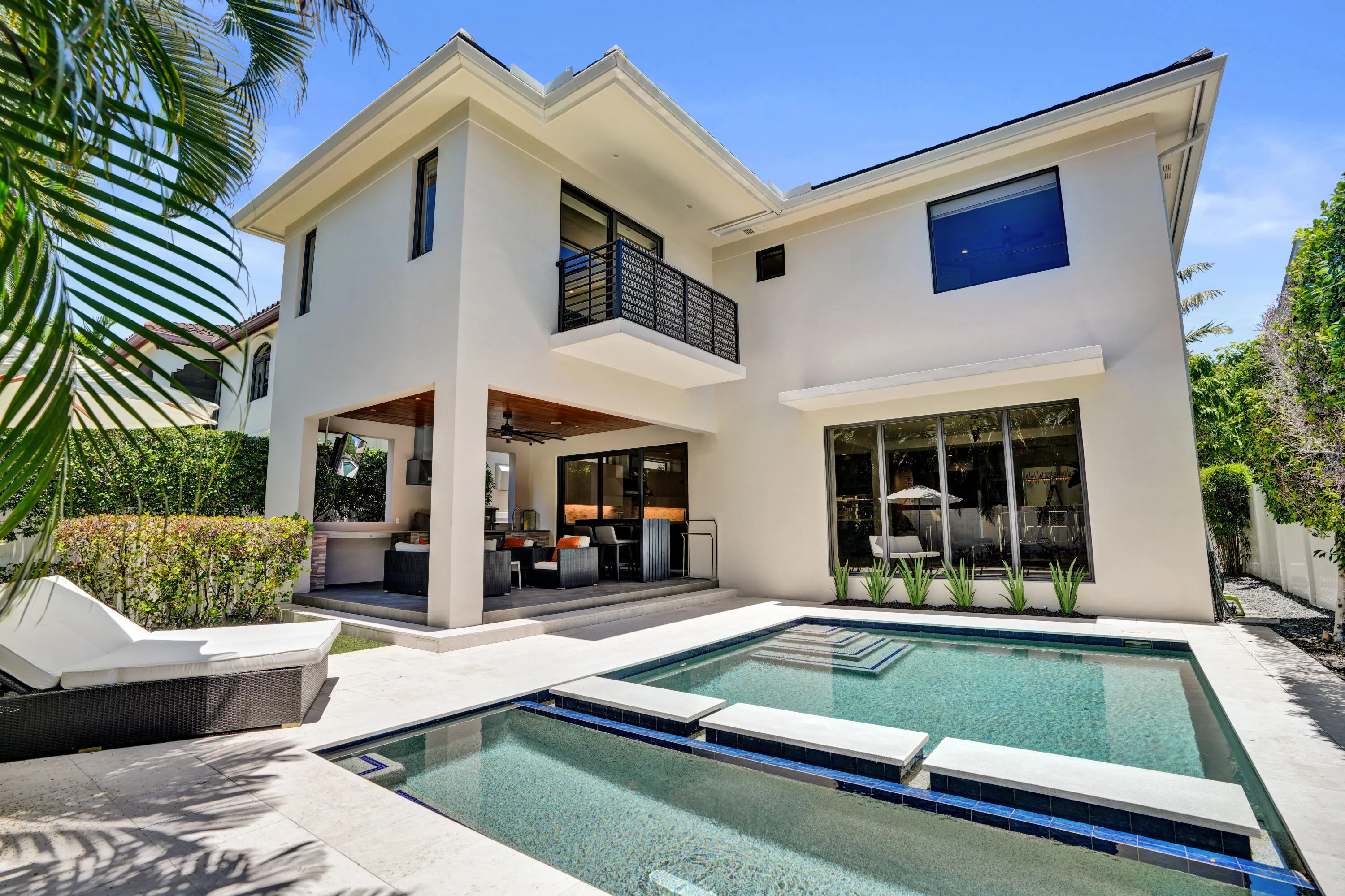 Stunning backyard pool area with covered patio, full service summer kitchen and maintenance free astroturf.