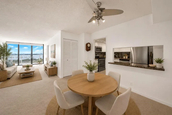 Beautifully digitally staged living and dining space, offering a captivating view of the balcony.