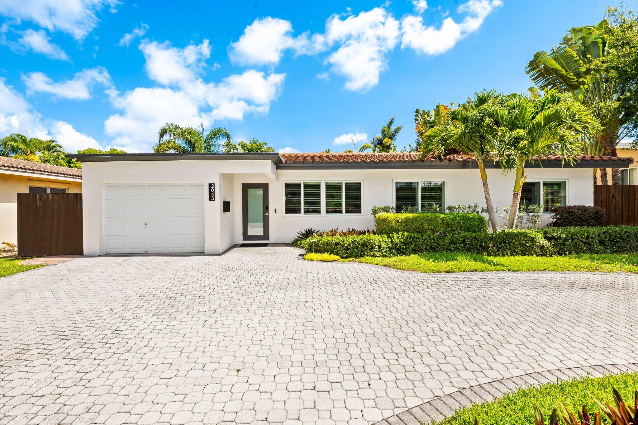 Front exterior of home illustrating the circular paver drive and one car garage.