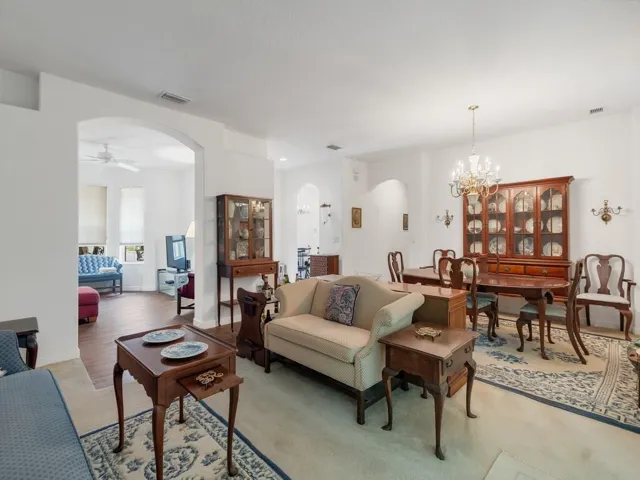 Spacious living area featuring light-toned walls, wood-finish flooring, and direct access to an outdoor screened patio
