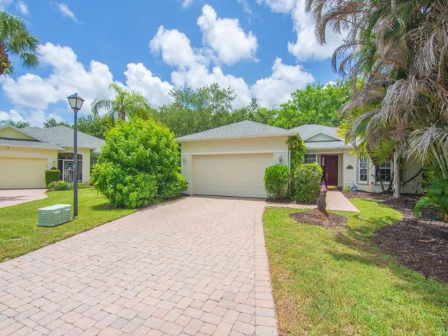 Single-story residence featuring a two-car garage, paver driveway, and a coordinating paver walkway leading to the front entry
