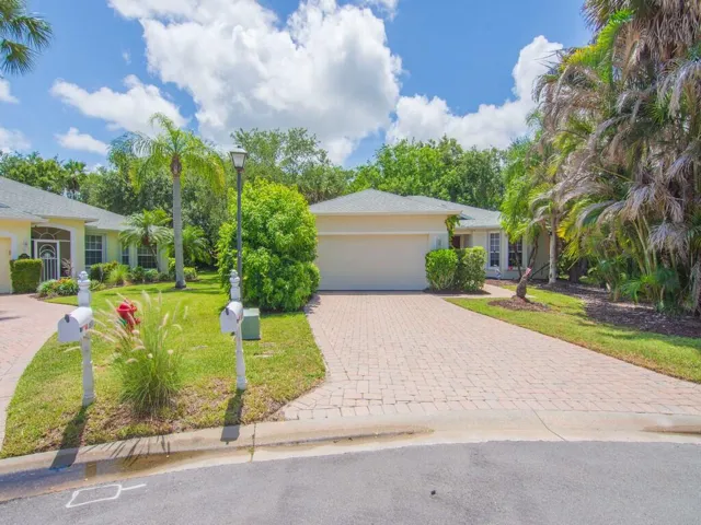Single-story residence featuring a two-car garage, paver driveway, and a coordinating paver walkway leading to the front entry