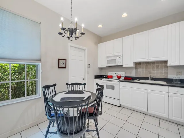 Kitchen featuring white cabinetry, dark countertops, a tile backsplash, and stainless steel appliances