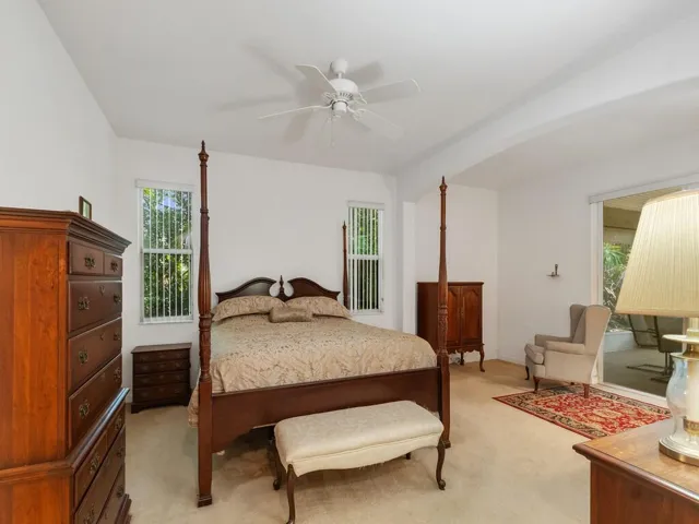 Spacious room featuring vaulted ceilings, a ceiling fan, and carpeted flooring