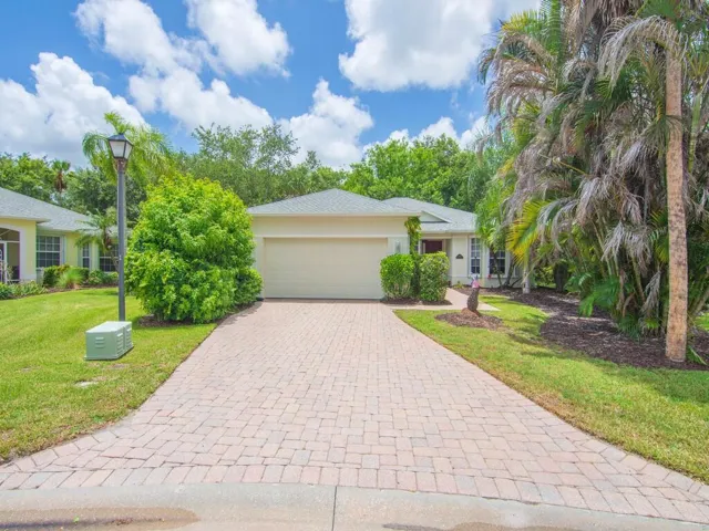 Single-story residence featuring a two-car garage, paver driveway, and a coordinating paver walkway leading to the front entry