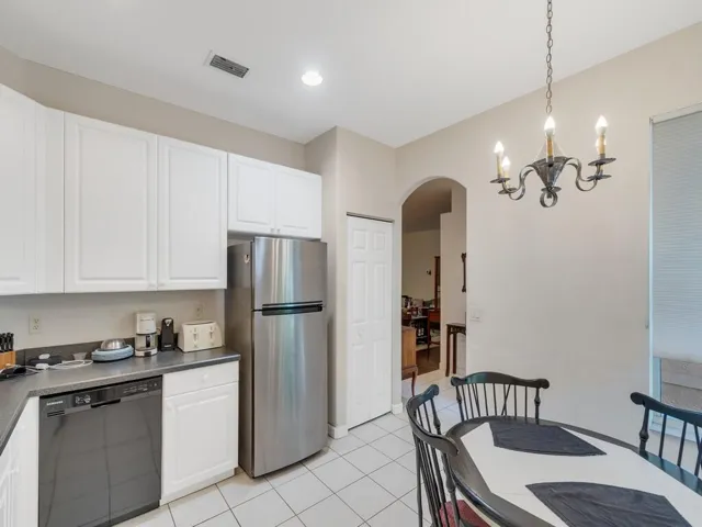 Kitchen featuring white cabinetry, dark countertops, a tile backsplash, and stainless steel appliances