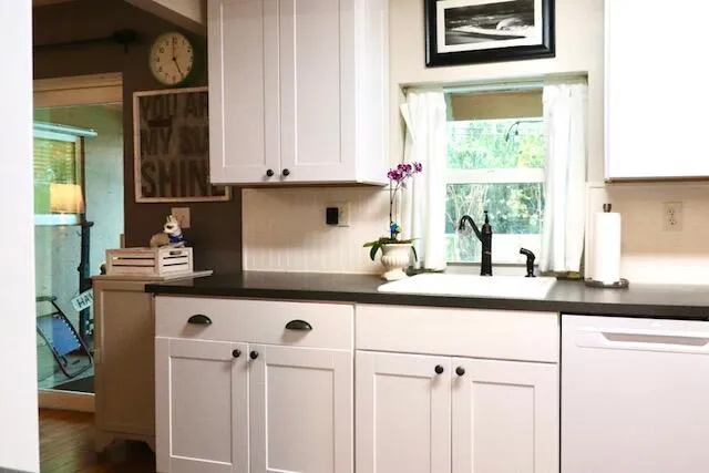Kitchen window frames pool/patio view with nice counter space and dishwasher