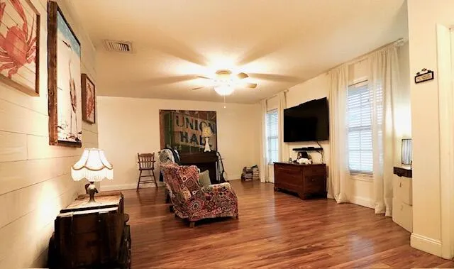 Generously sized living room with rich wood-like laminate flooring.