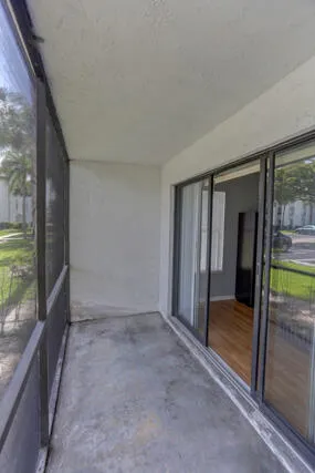 Screened porch overlooks entryway and shaded parking.