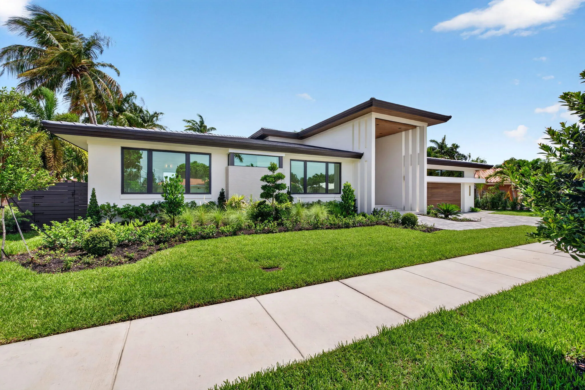 Modern single-story architecture creates strong curb appeal with a refined entry sequence and manicured Fort Lauderdale setting.