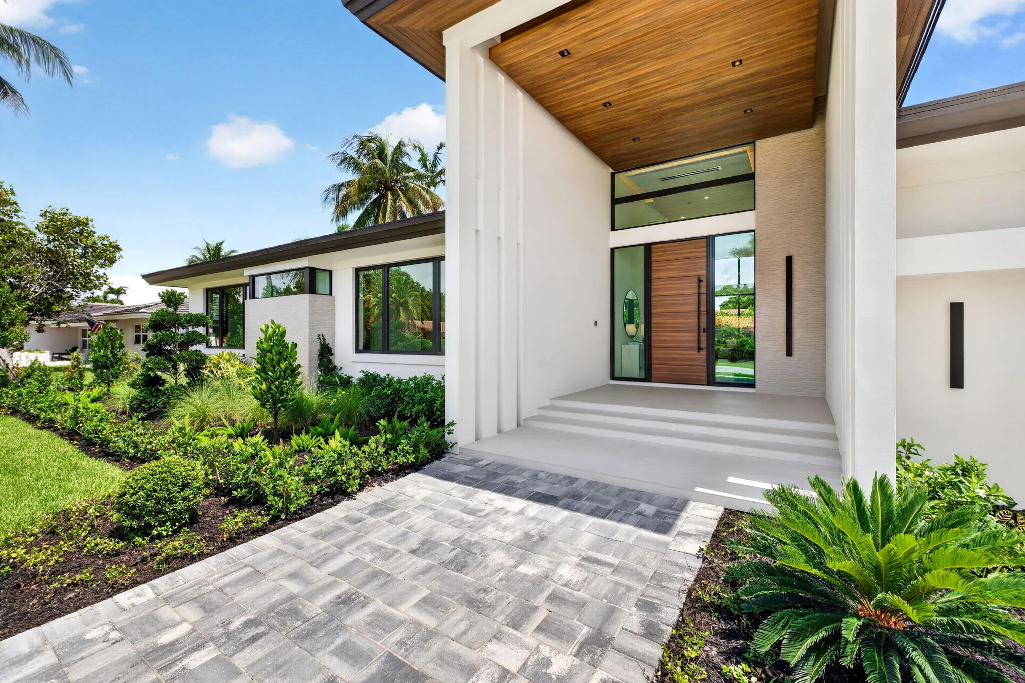 The front elevation highlights custom architecture, crisp rooflines, and a welcoming approach to this newly completed residence.
