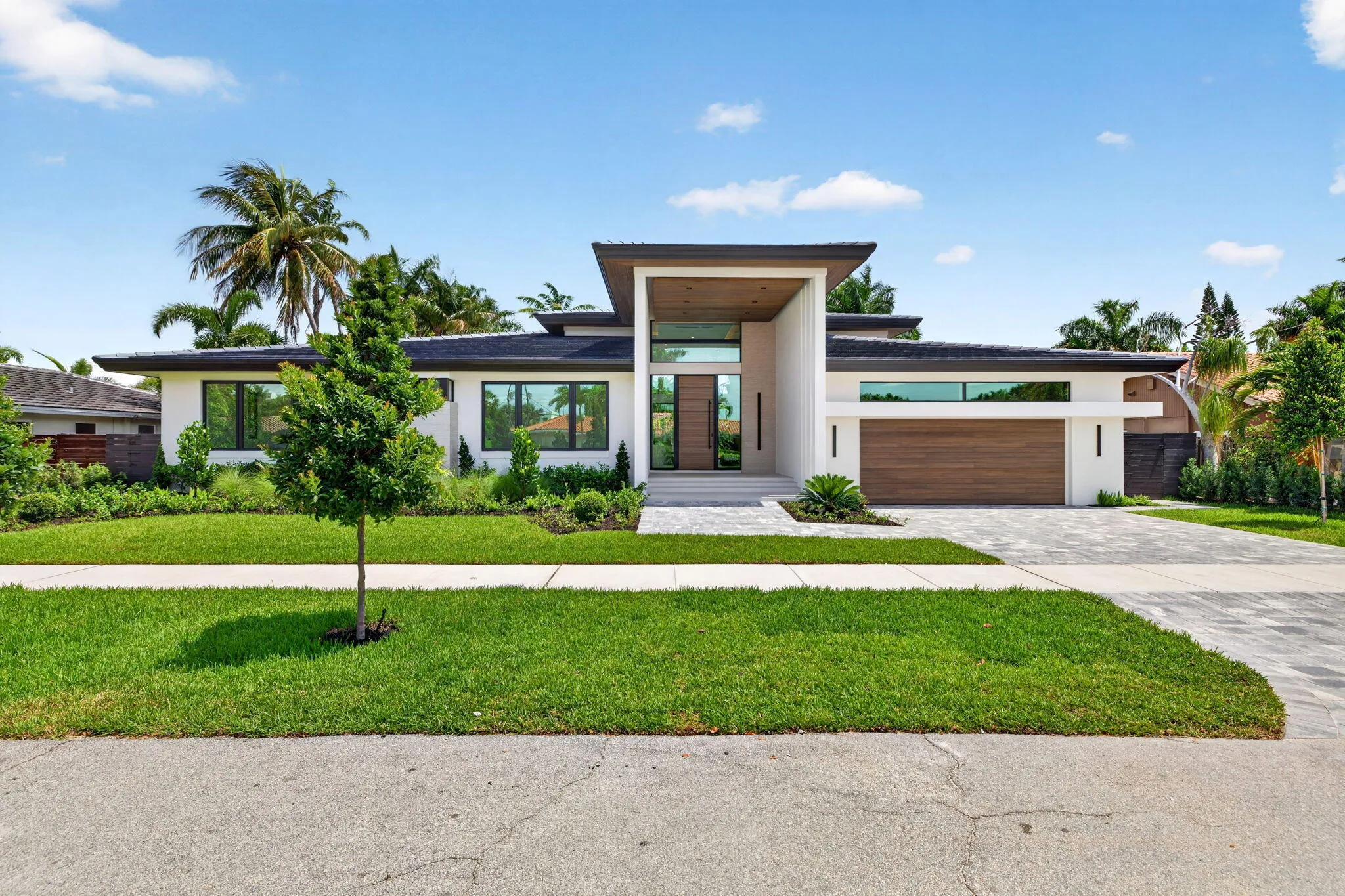 The front elevation highlights custom architecture, crisp rooflines, and a welcoming approach to this newly completed residence.