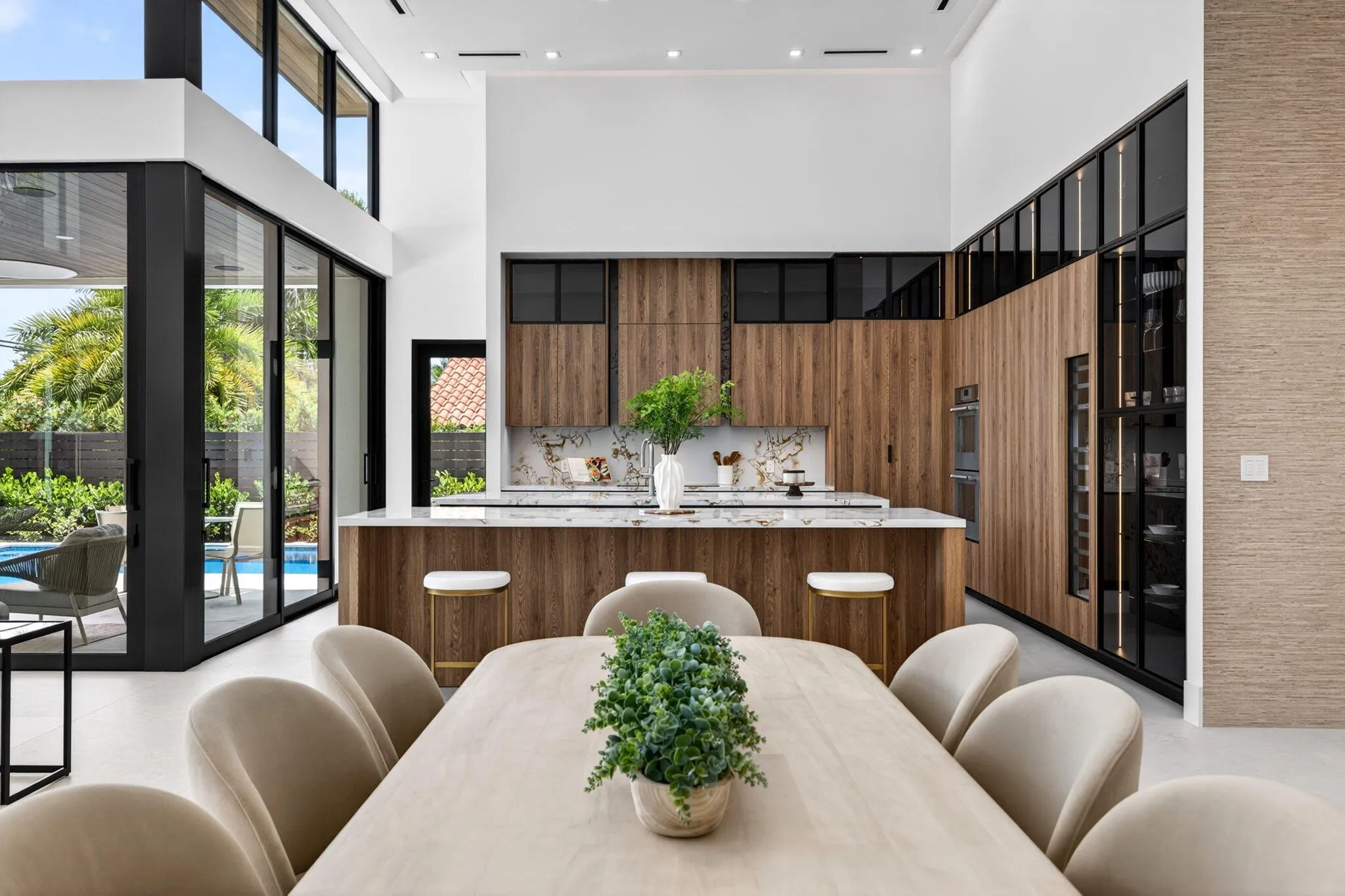 A refined kitchen view highlights generous prep areas, warm cabinetry, elegant stone surfaces, and strong indoor-outdoor flow.