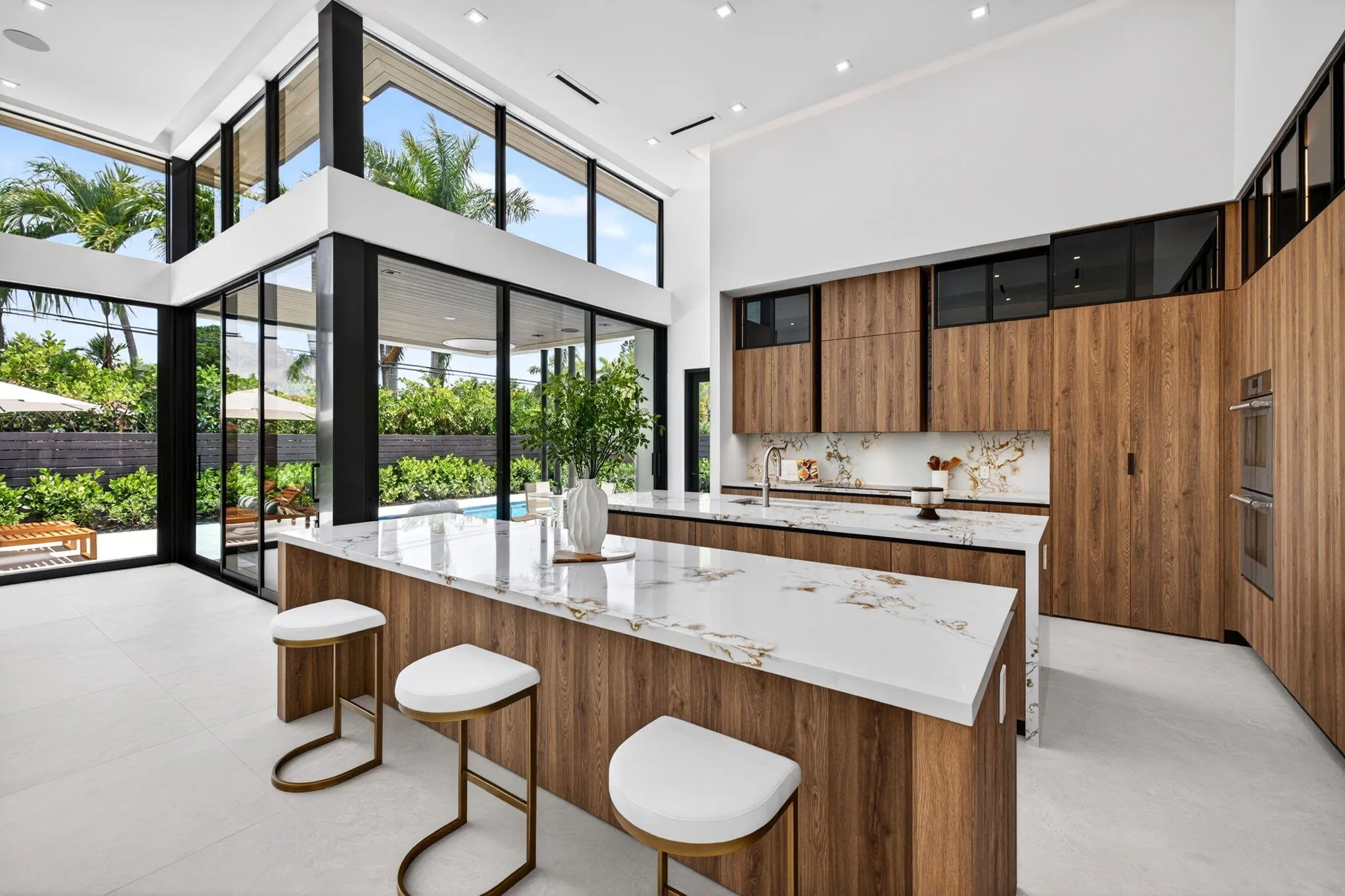 The kitchen combines sculptural design and daily function with premium appliances, custom storage, and polished modern finishes.