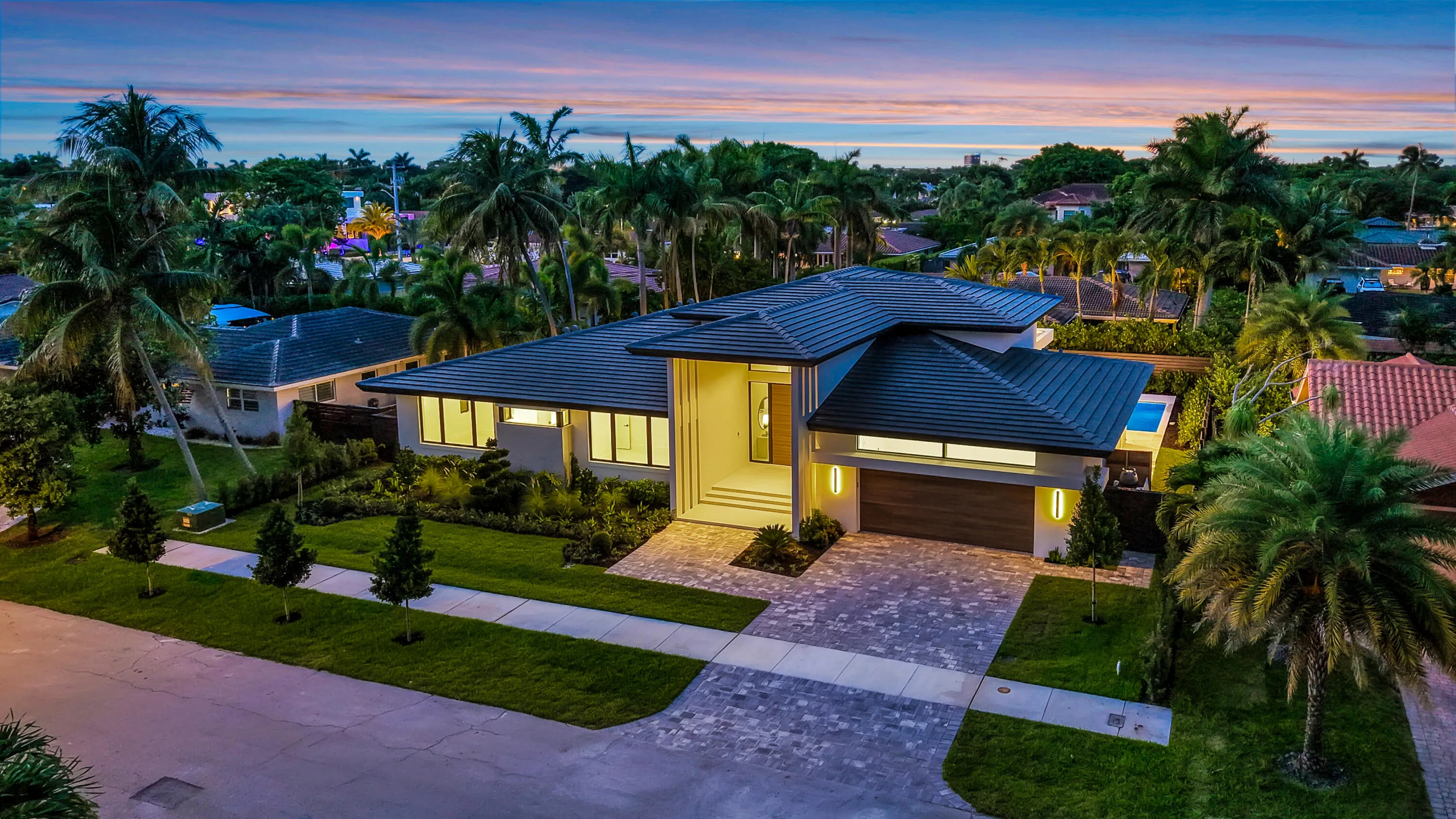 Modern single-story architecture creates strong curb appeal with a refined entry sequence and manicured Fort Lauderdale setting.