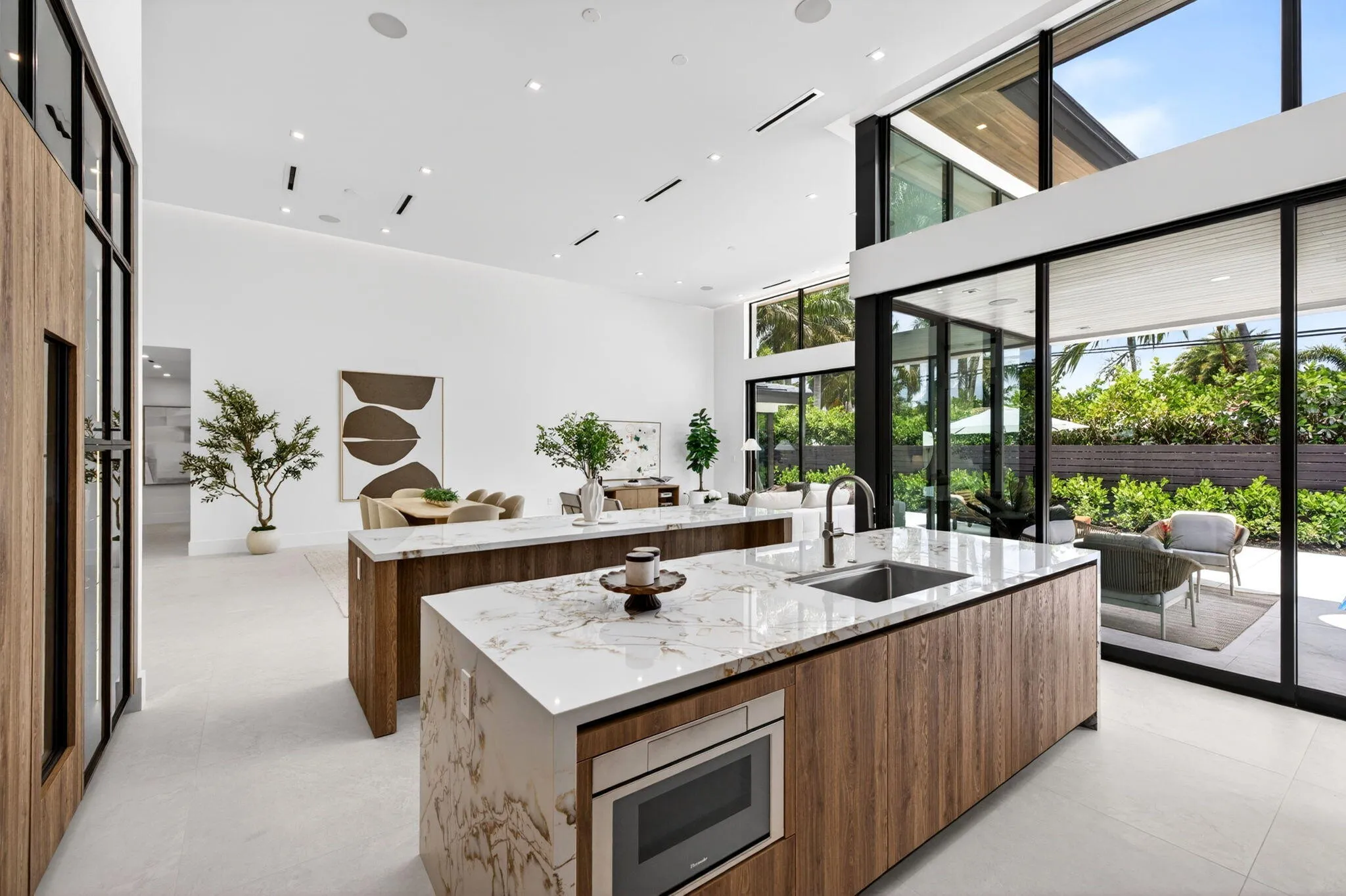 A refined kitchen view highlights generous prep areas, warm cabinetry, elegant stone surfaces, and strong indoor-outdoor flow.
