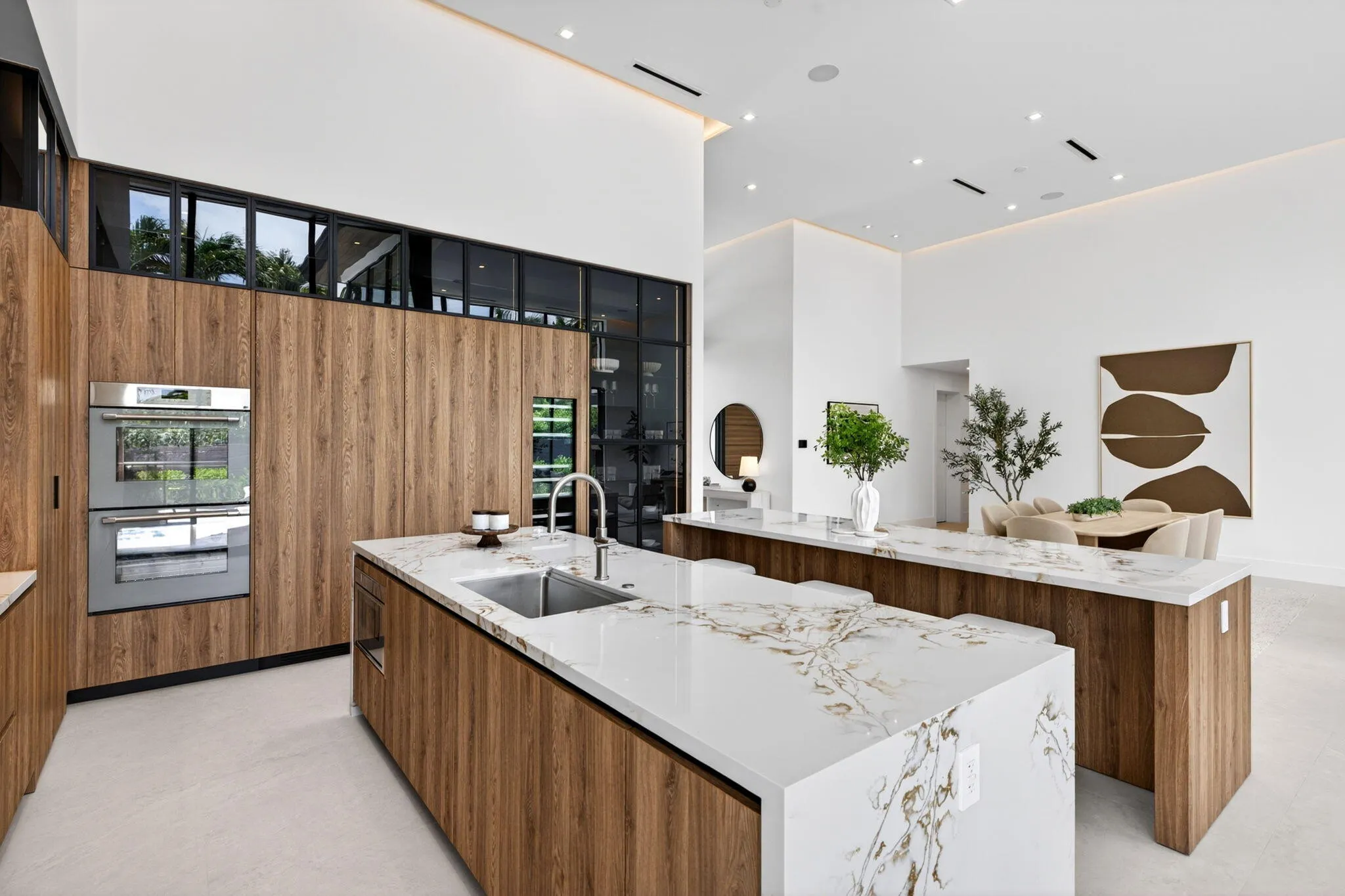 A refined kitchen view highlights generous prep areas, warm cabinetry, elegant stone surfaces, and strong indoor-outdoor flow.