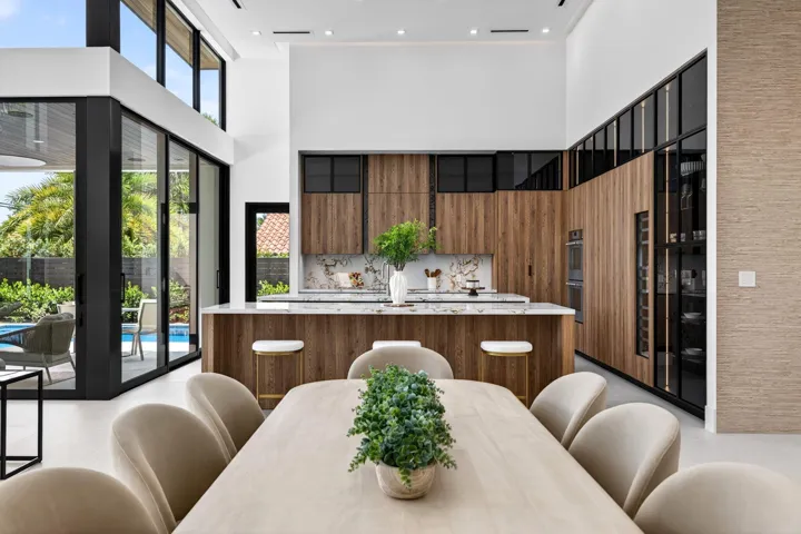 A refined kitchen view highlights generous prep areas, warm cabinetry, elegant stone surfaces, and strong indoor-outdoor flow.