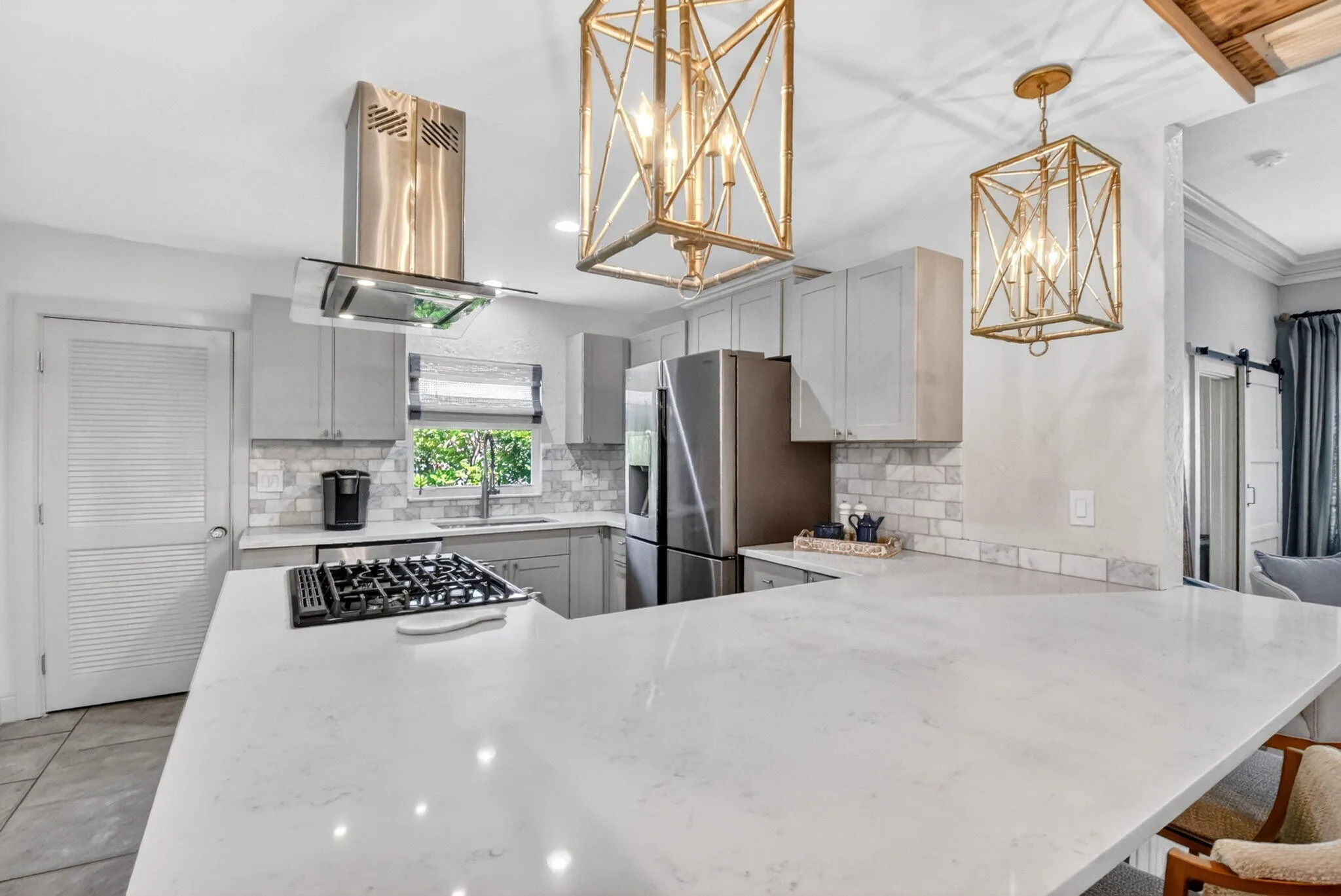 Beautifully updated kitchen quartz counters, shaker cabinets, gas stove and modern appliances.