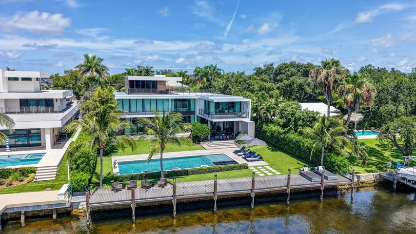 An extraordinary aerial perspective highlighting the home's expansive waterfront footprint, private dockage, resort-style grounds, and dramatic ambiance.