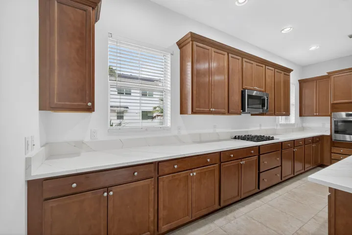 Large kitchen, stainless steel appliances, and quartz counters.