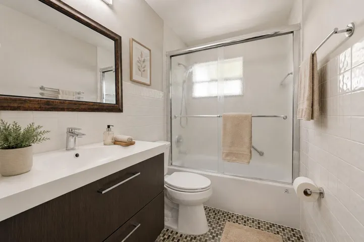 Virtually staged full bathroom with tub featuring a clean, functional design.