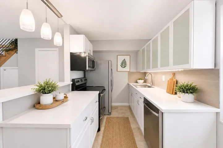 Virtually staged kitchen highlighting the functional layout and connection to the main living area.