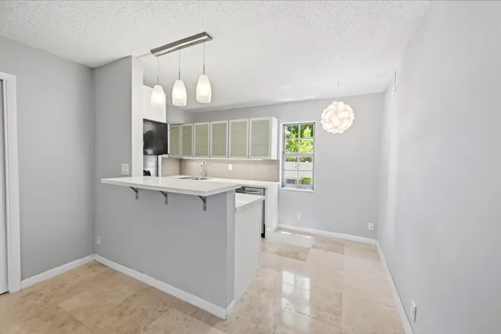 Kitchen featuring stainless steel appliances, beautiful cabinetry, and an adjoining dining area.