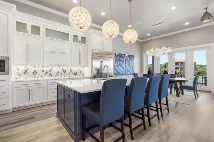 Stunning designer lighting, ample custom cabinetry, and an oversized gathering island make this impressive kitchen as functional as it is unforgettable.