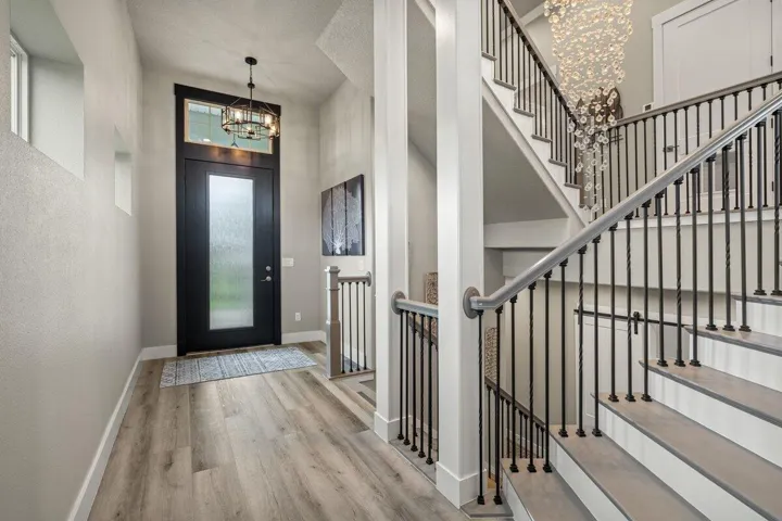 Rich in luxury and sophistication, this impressive second-floor foyer showcases soaring ceilings, custom iron railings, and a dazzling statement chandelier that instantly elevates the entire home.