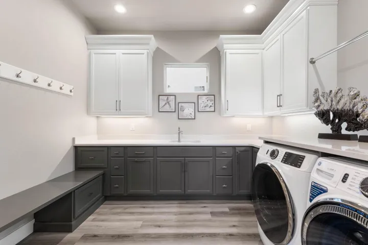 1st Floor laundry room is thoughtfully designed with extensive cabinetry, built-in storage, and a spacious folding station, this oversized laundry room brings beauty and ease to everyday living