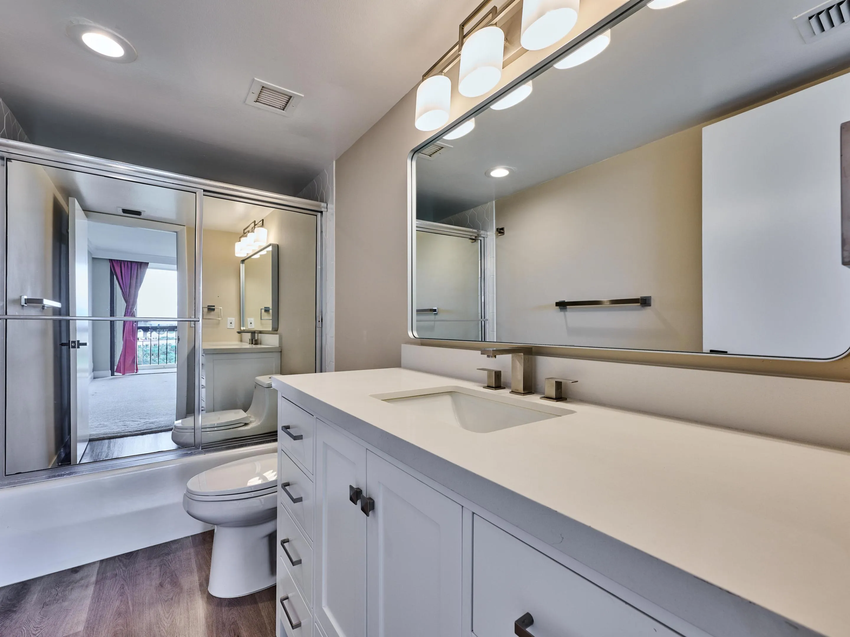 New quartz counter, new lighting, flooring, mirror, towel bars and shower fixtures update the primary bath.
