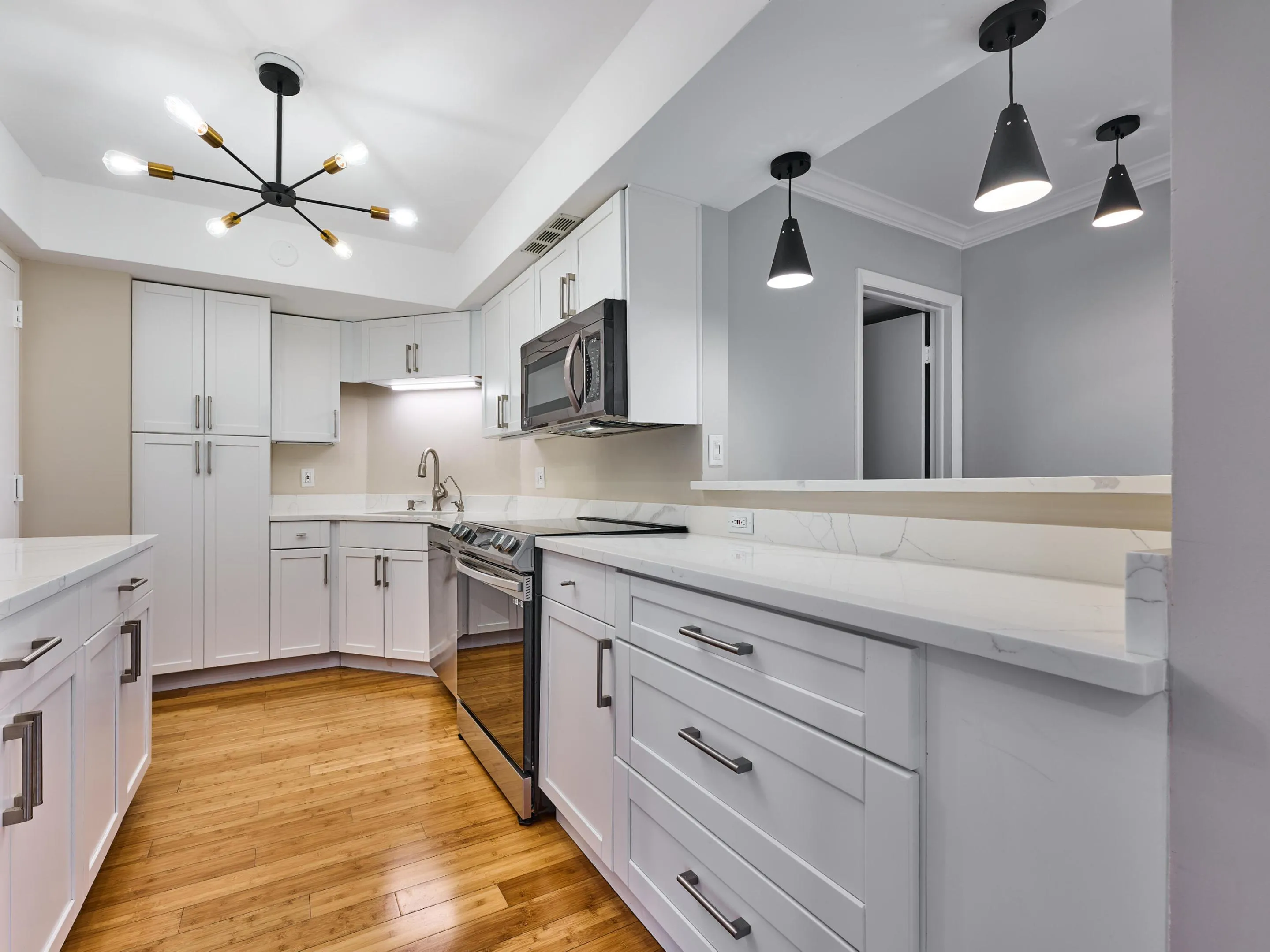 The fully renovated kitchen features quartz counters, stainless appliances, new lighting and plenty of workspace and storage.