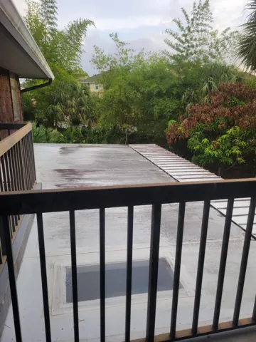 Porch below the balcony and skylights that add natural light into the screened in porch area.