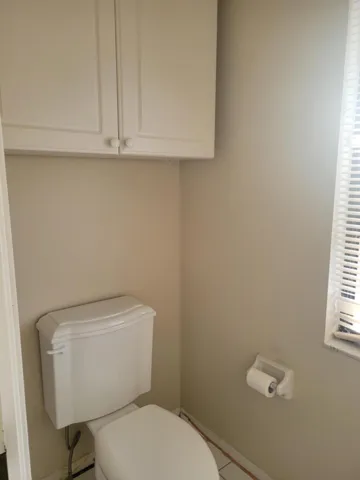 Master privy has pocket door for privacy and window for natural light.