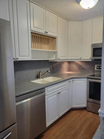 Stainless steel Dishwasher Laminate flooring throughout the downstairs living area, note the undermount down lighting under top cabinets.