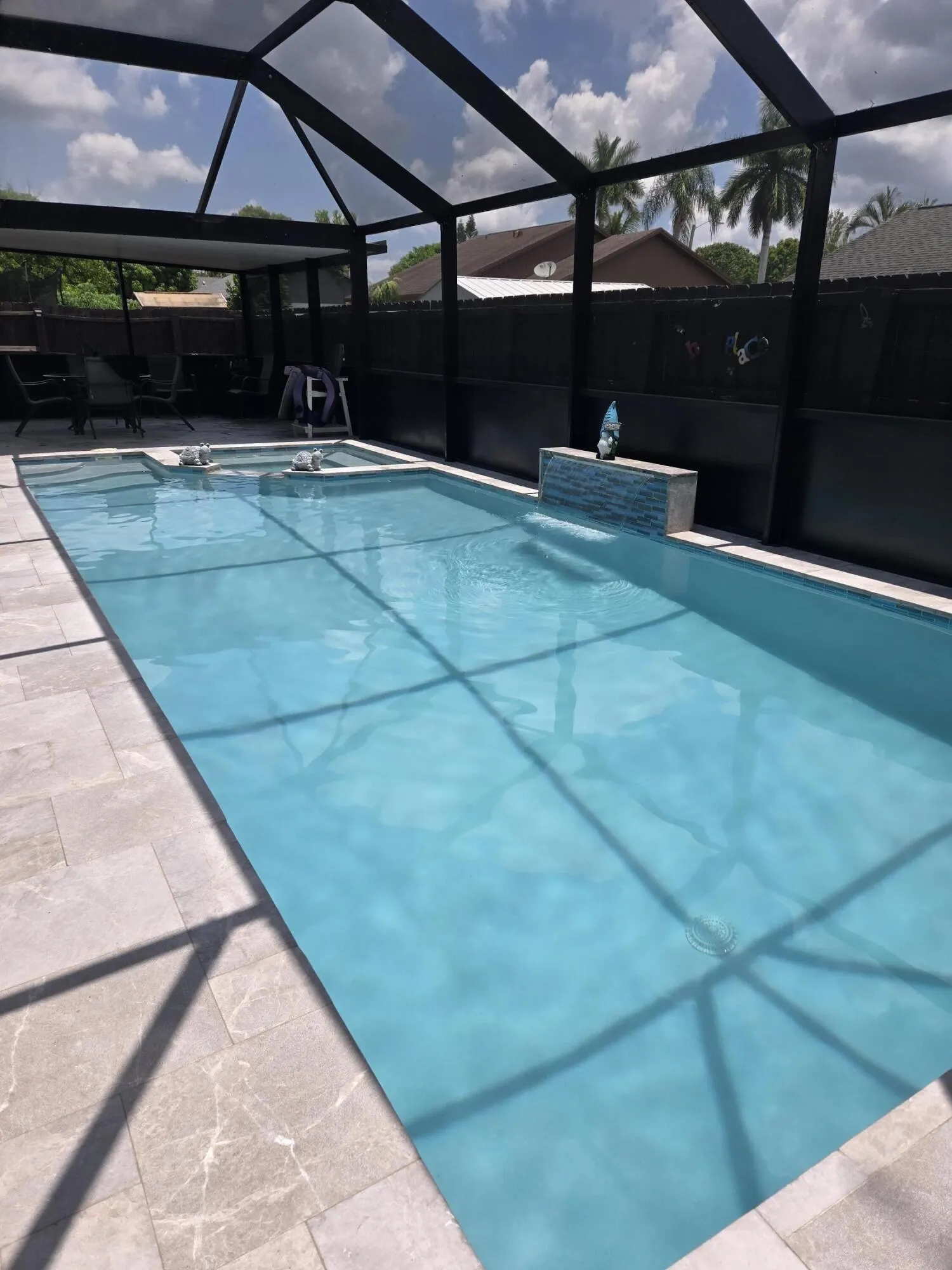 Pool area with waterfall surrounded by marble Pool Deck