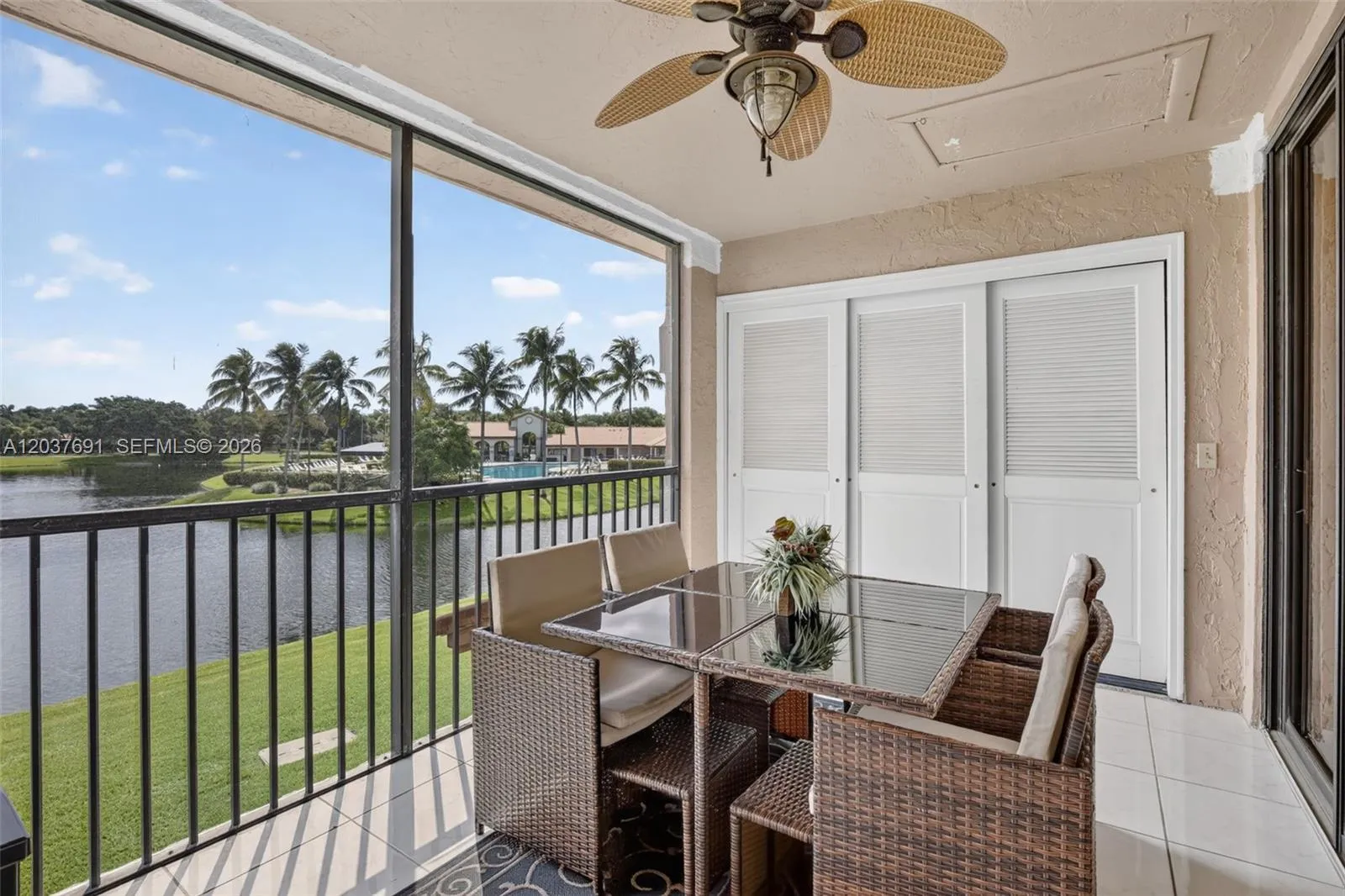 Screened balcony overlooks the lake, pool and clubhouse—perfect for relaxing or dining outdoors