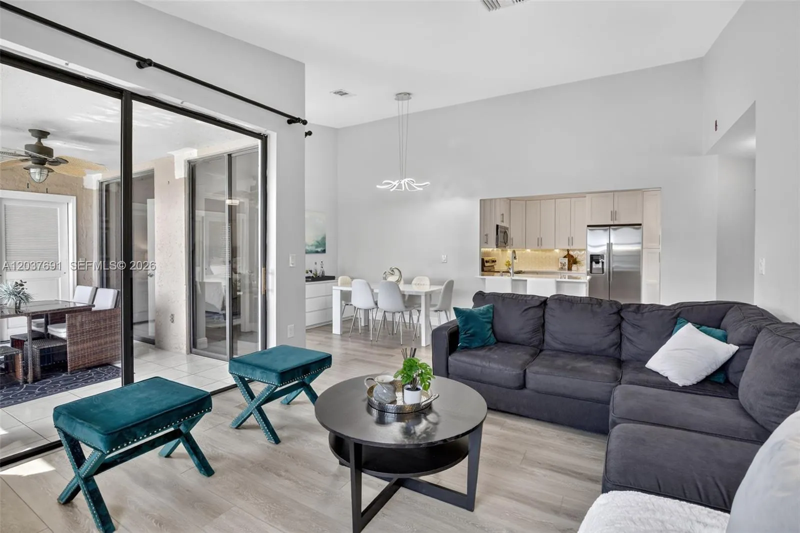Open concept living features spacious living room, remodeled kitchen, luxury vinyl plank flooring throughout, smooth ceiling finish, tiled balcony and seamless indoor-outdoor flow