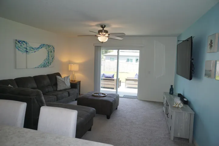 Spacious living area featuring light-toned carpeting and neutral wall colors