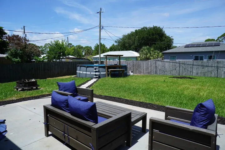 Spacious backyard featuring a concrete patio, expansive lawn, and wood privacy fencing