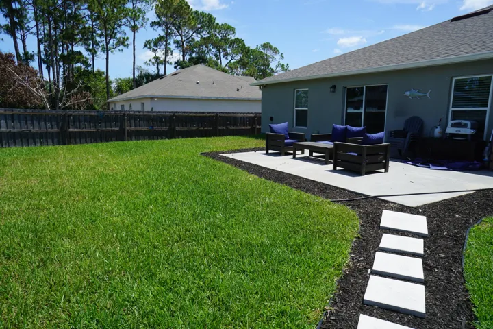 Expansive green lawn with a full privacy fence