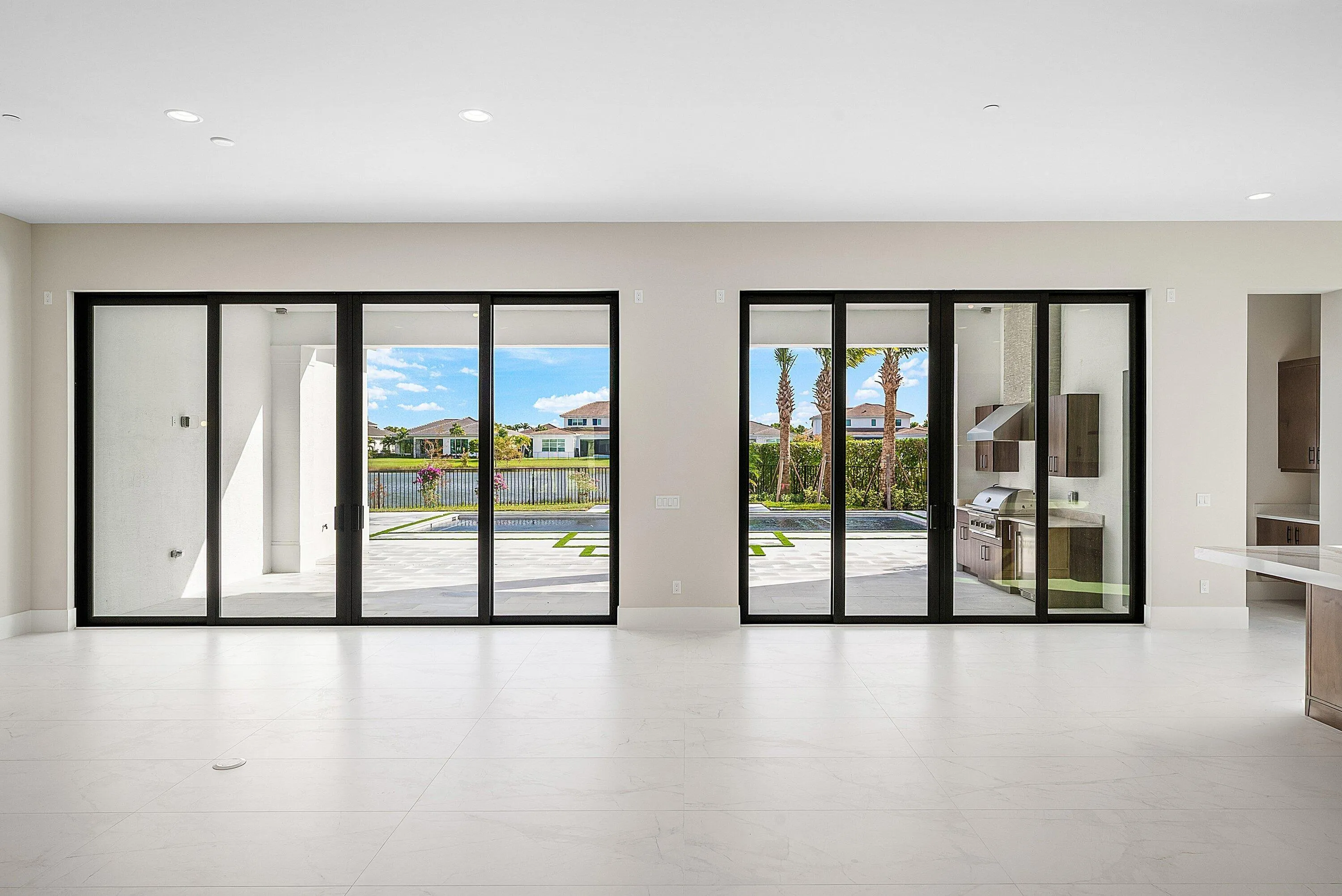10' Sliding Glass Doors lead to large covered Lanai with Built-in Summer Kitchen. {NOTE: Lot 89 Photo for Reference Only}