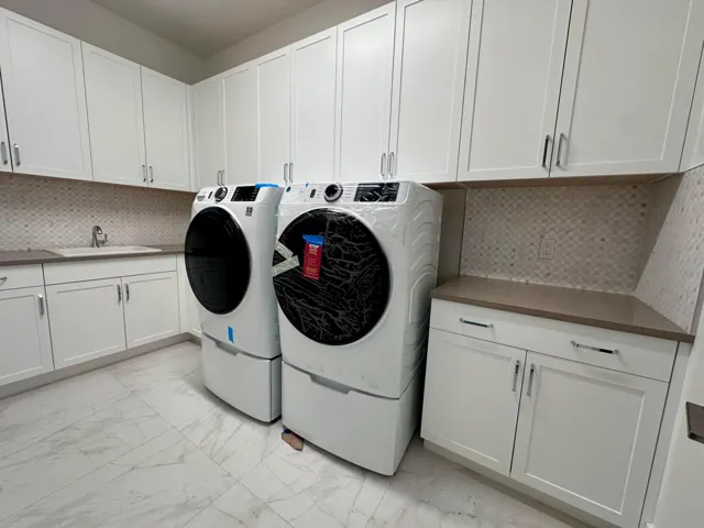 Beautiful mosaic Backsplash in 1st Floor Laundry Room, Gas Front Load Dryer, both W&D on Storage Pedestals
