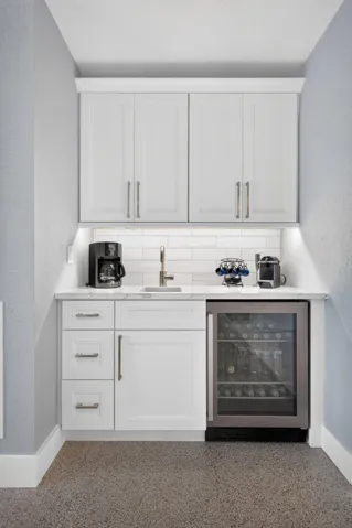 Wet bar located in the living room with beverage refrigerator.