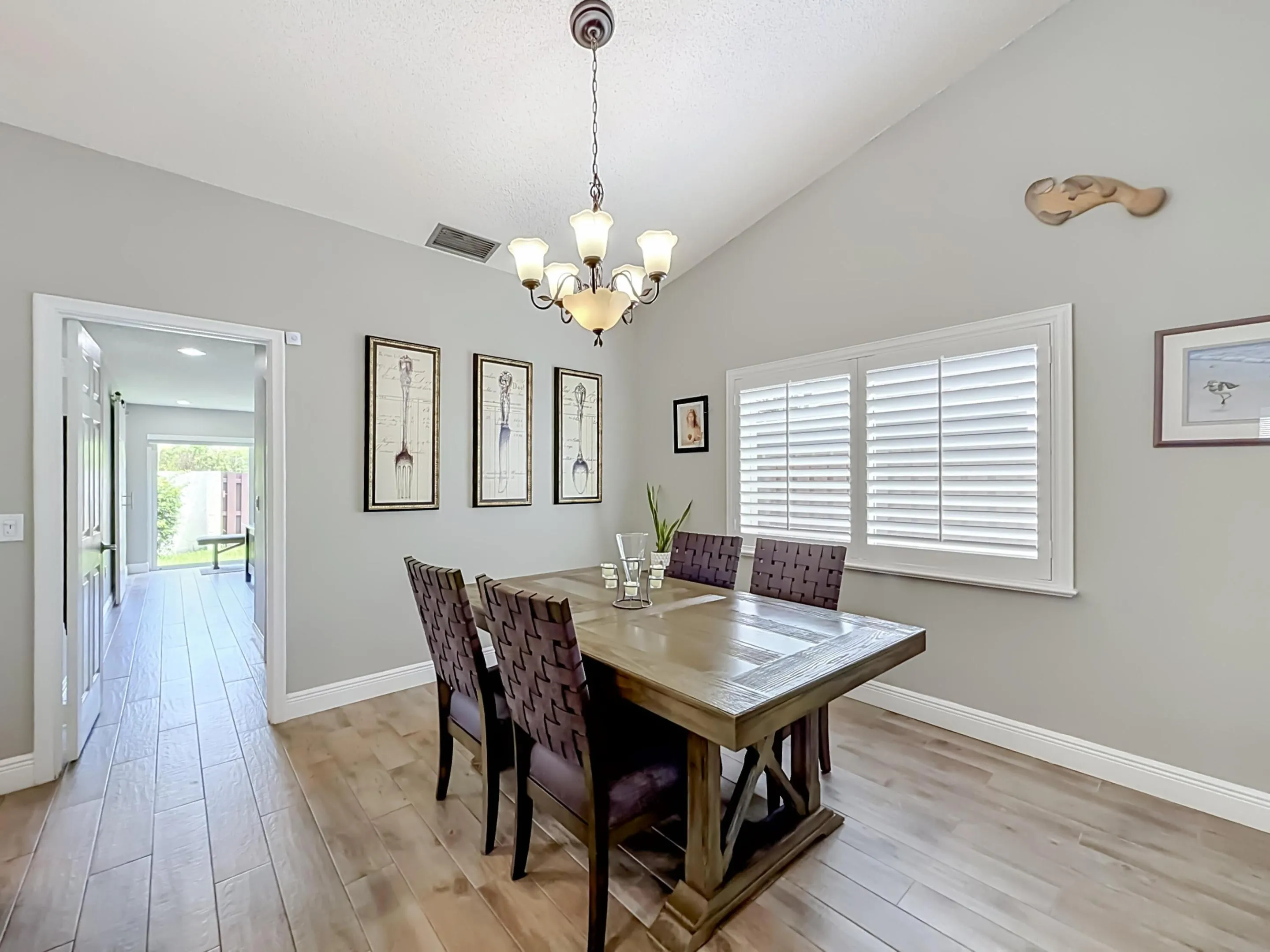 Dining area, side yard view, plantation shutters, vaulted ceilings, entrance to primary