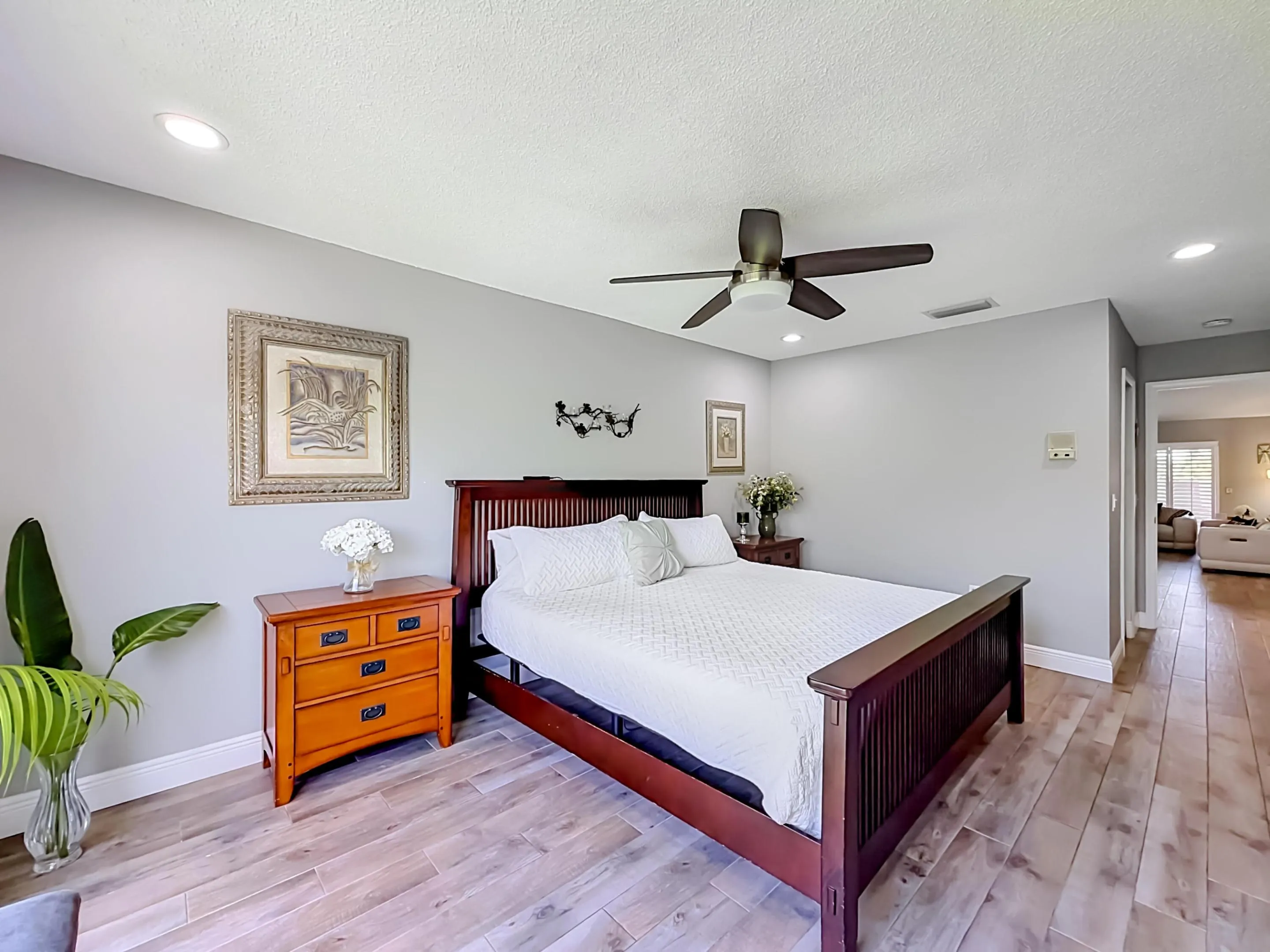 Primary Bedroom with modern fan, fits king bed with end table, seated area